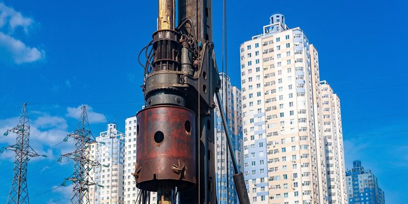 machine for drilling deep piles against the backdrop of residential areas